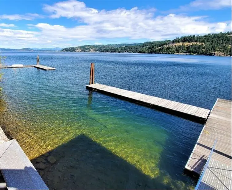 Lake with docks and distant forested hills.