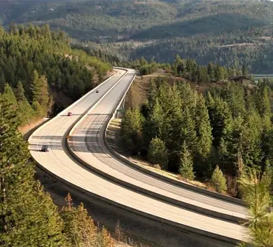 Mountain highway surrounded by dense green forest.