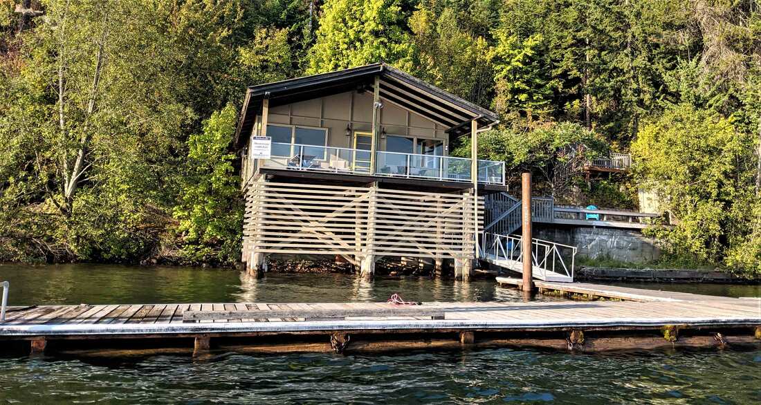 Lakeside house with dock and trees.